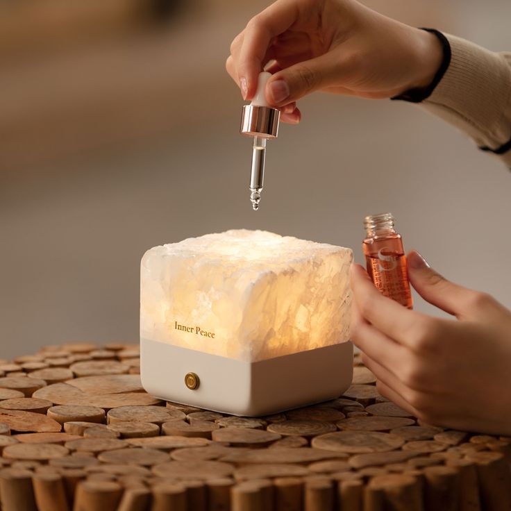 a person is lighting a small light on top of a block of ice with a lighter in it