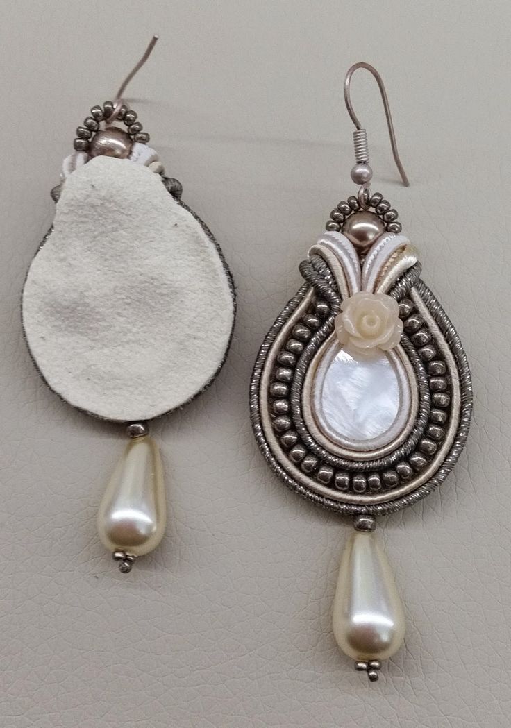 two pairs of earrings with pearls hanging from them