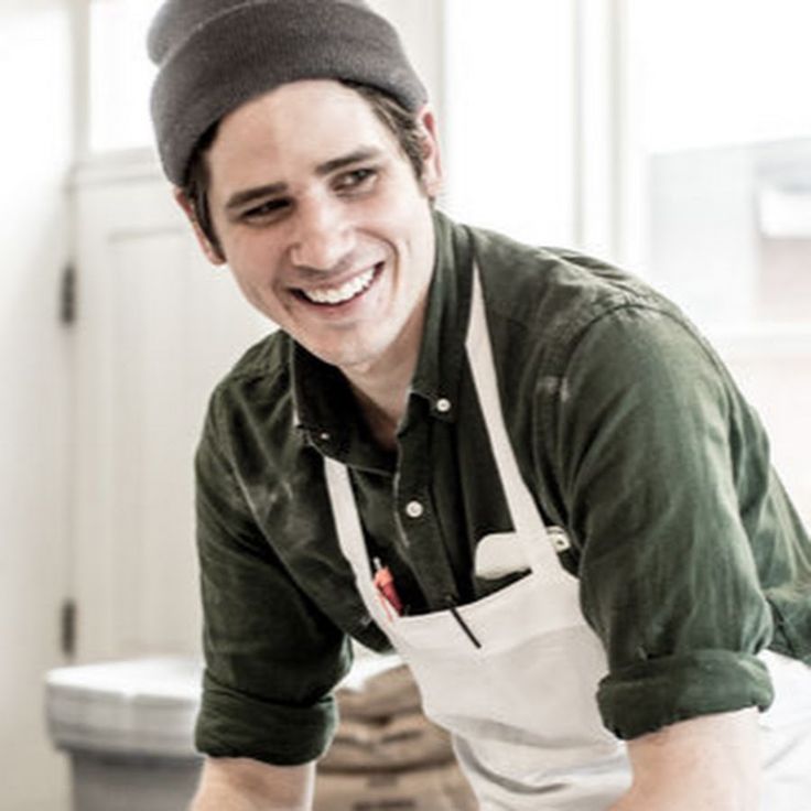 a smiling man in an apron and hat