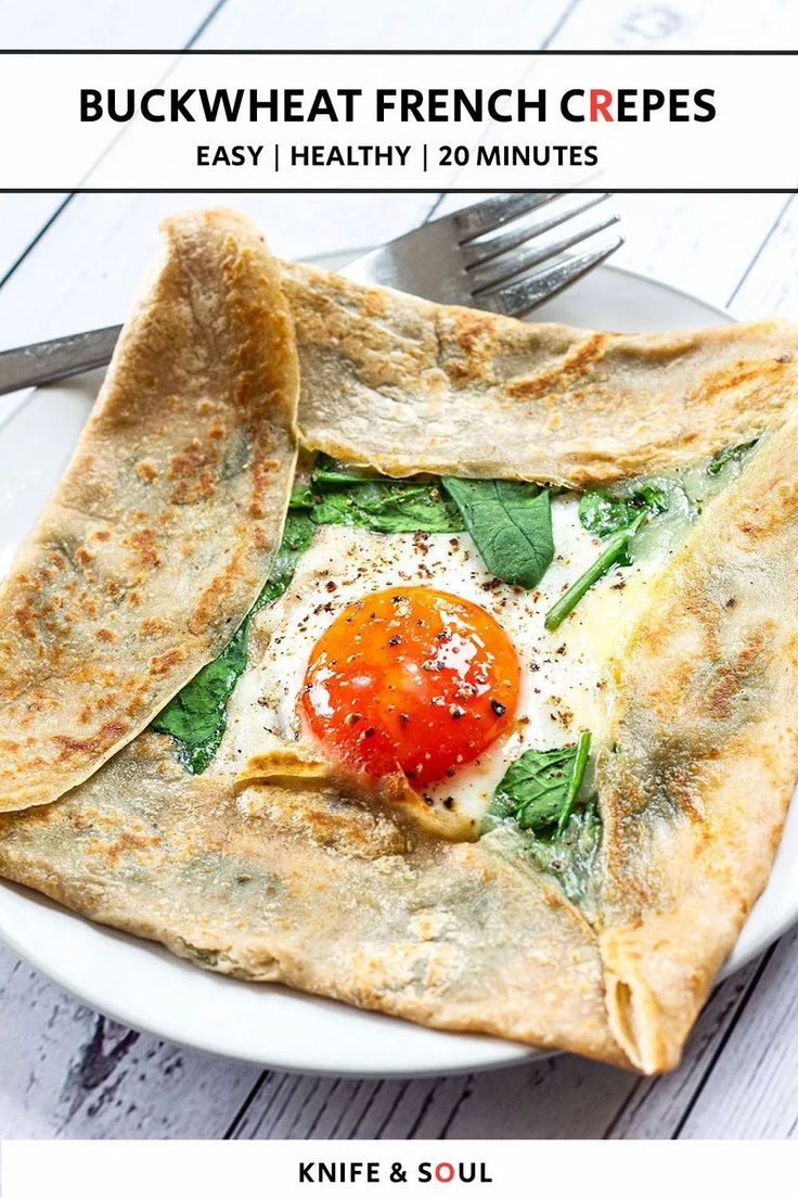 a white plate topped with an egg and spinach quesadilla next to a fork