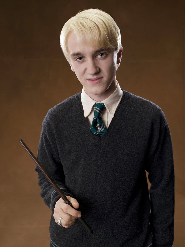 a young man with blonde hair holding a wand