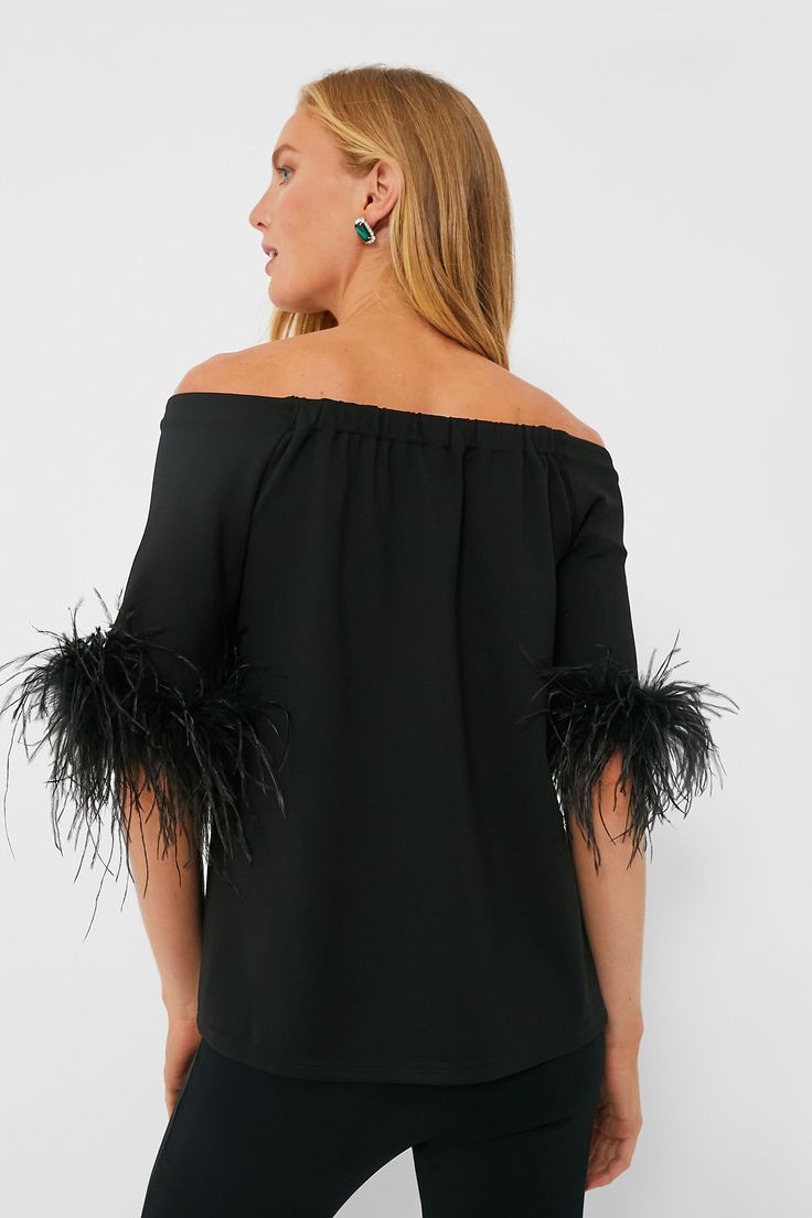 A fan favorite, now updated with feathers for an extra bit of fun, the Black Miranda Off The Shoulder Blouse is our idea of a good time. Modern and chic with a minimalist silhouette, this effortlessly elevated top is made from a soft fabric with elbow-length sleeves and a swingy A-line shape that's sure to flatter. Pair with denim and bold jewelry for an elevated date night look, or go for the coordinating Feather Ashford Pants and a clutch for party time! Off-the-shoulder neckline Elbow-length Fitted Feather Tops For Fall, Fitted Feathered Tops For Fall, Chic Feathered Tops For Fall, Feather Trim Tops For Night Out In Spring, Spring Night Out Tops With Feather Trim, Elegant Feather Tops For Summer, Summer Party Tops With Feathers, Elegant Feathered Evening Tops, Chic Spring Tops With Feather Trim