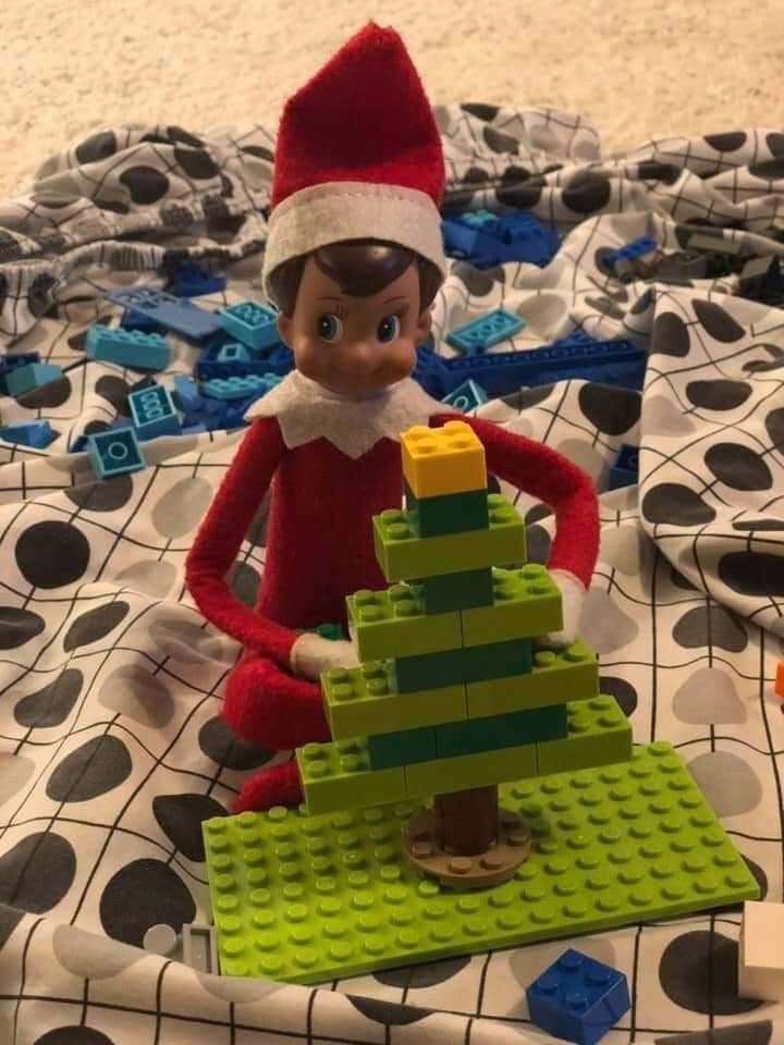 an elf with a lego christmas tree on the bed