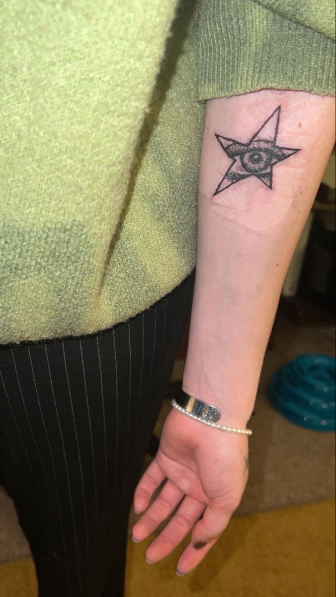 a woman's arm with a star tattoo on it