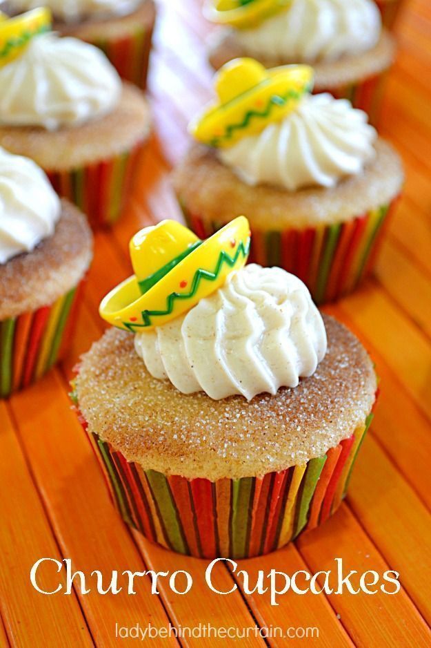 several cupcakes with white frosting and yellow decorations on top are sitting on a wooden table