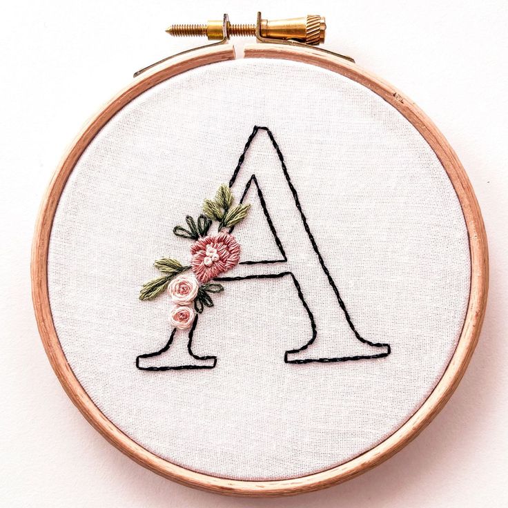 an embroidered letter with flowers on it