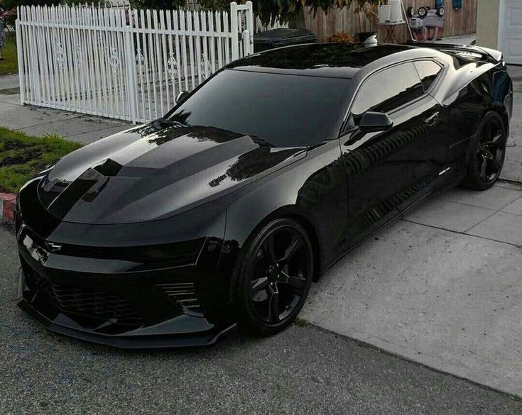 a black sports car parked in front of a house