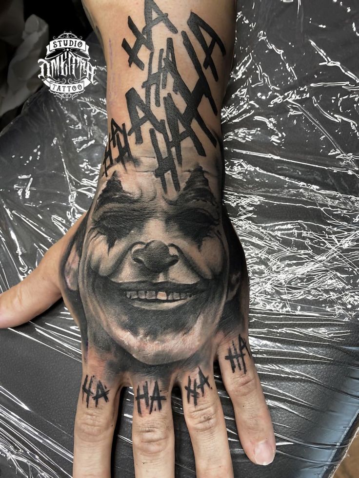 a man's hand with an evil face tattooed on it