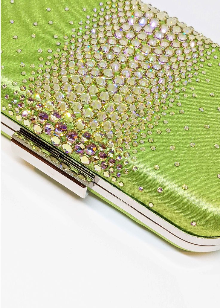 Add a pop of color with this LIMITED EDITION glamorous satin clutch — ELLA is adorned with the highest quality brilliant cut crystals to add the perfect touch of sparkle to any look. Perfect for pairing with a vibrant evening gown to bring out its designs, the Ella Crystal Clutch is a beautiful evening wear clutch with just enough detail to make the accents of your dress shine. Against a smooth and soft satin background layer are clear, sparkly crystals that are heavy in concentration and large Green Rhinestone Party Evening Bag, Glamorous Green Evening Bag, Luxury Green Embellished Clutch, Green Luxury Embellished Clutch, Elegant Green Evening Bag For Event, Green Elegant Evening Bag, Elegant Green Evening Bag For Events, Green Rhinestone Clutch Evening Bag, Elegant Green Evening Bag With Rhinestones