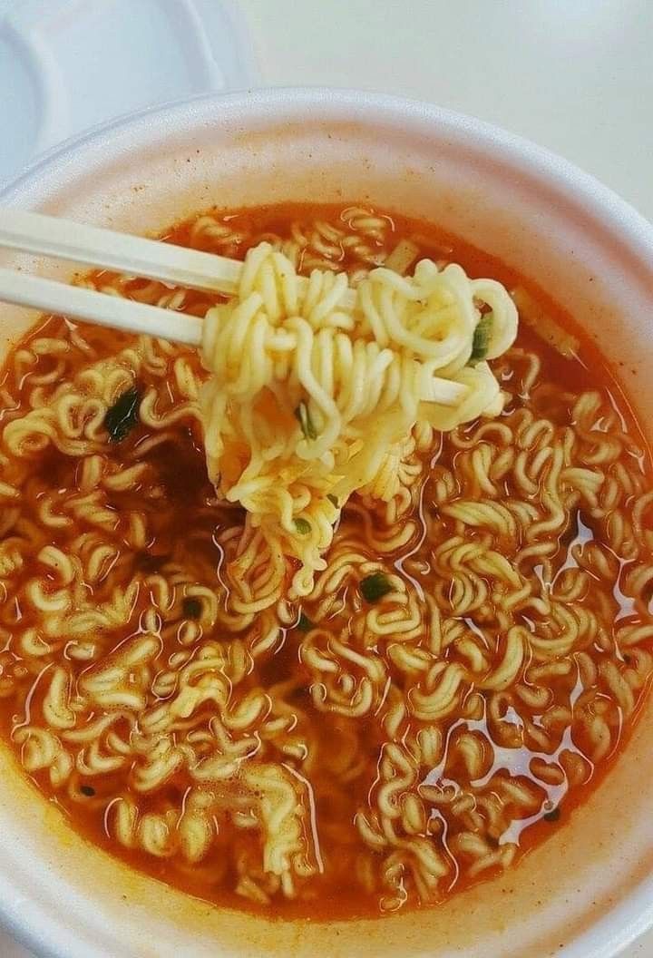 there is noodle soup in the bowl with chopsticks sticking out of it