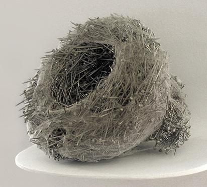 a ball of yarn sitting on top of a white shelf next to a black object