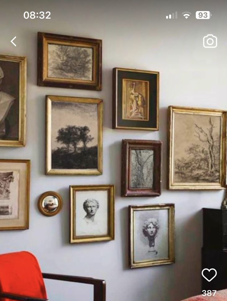 a bedroom with many framed pictures on the wall and a chair in front of it