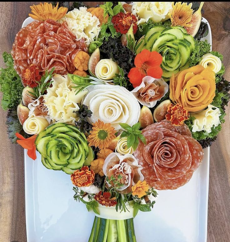 an arrangement of flowers arranged on a white platter