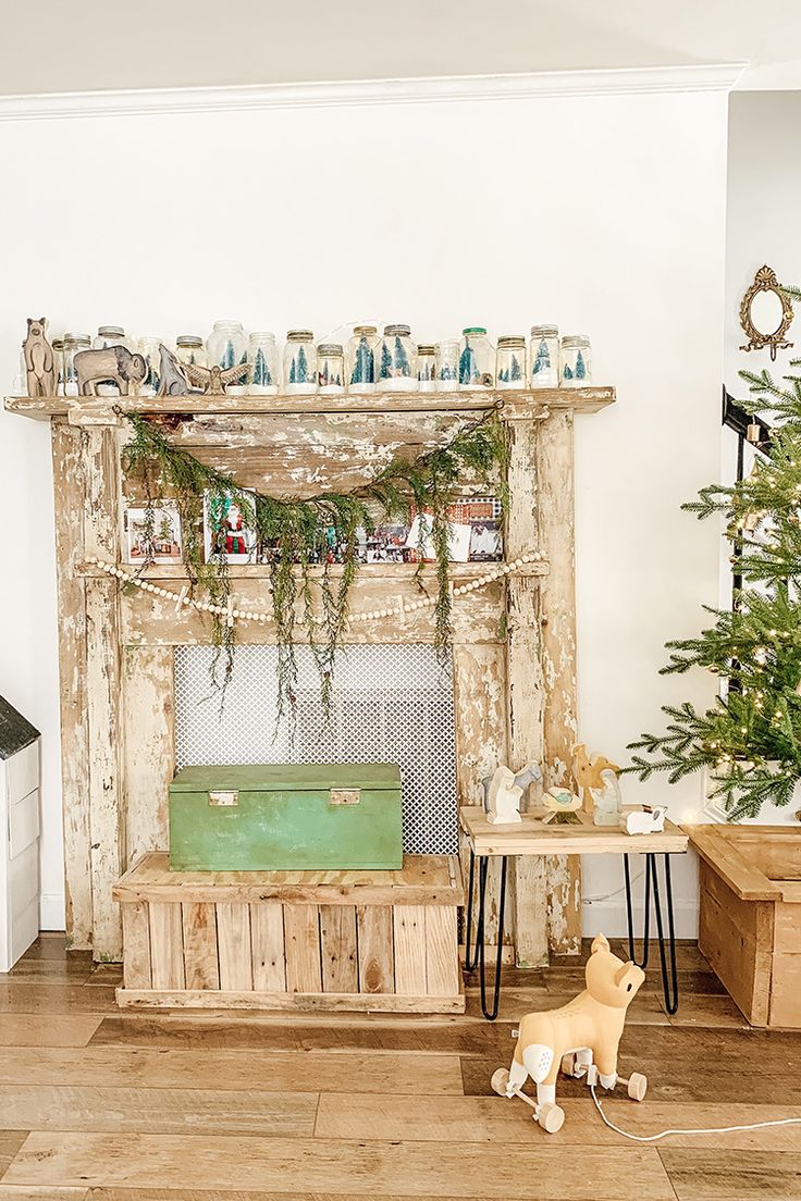 a dog is standing in front of a fireplace with christmas decorations on the mantel