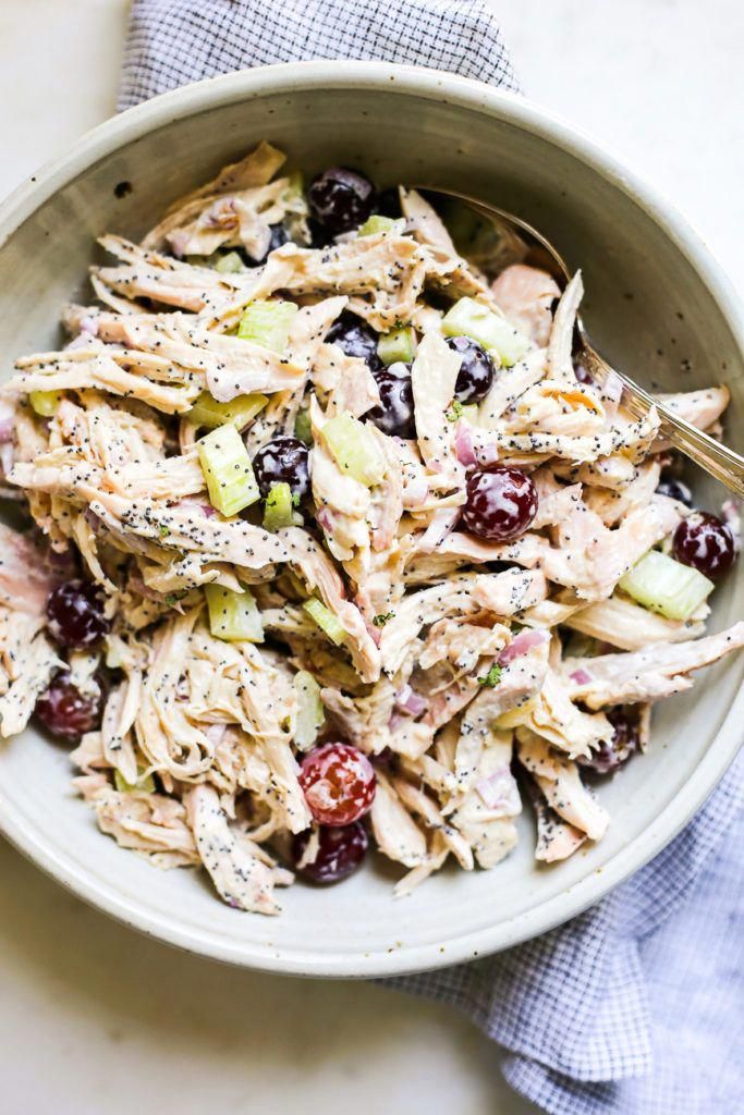 a white bowl filled with chicken salad on top of a table