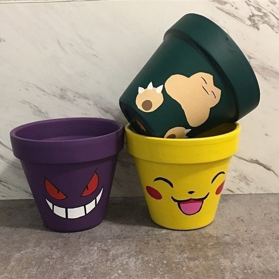 three plastic cups with faces on them sitting in front of a marble wall and floor