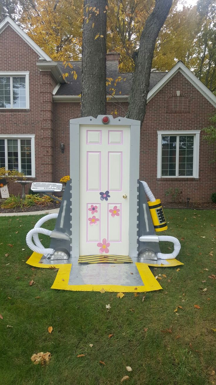 an inflatable door sitting on the grass next to a tree