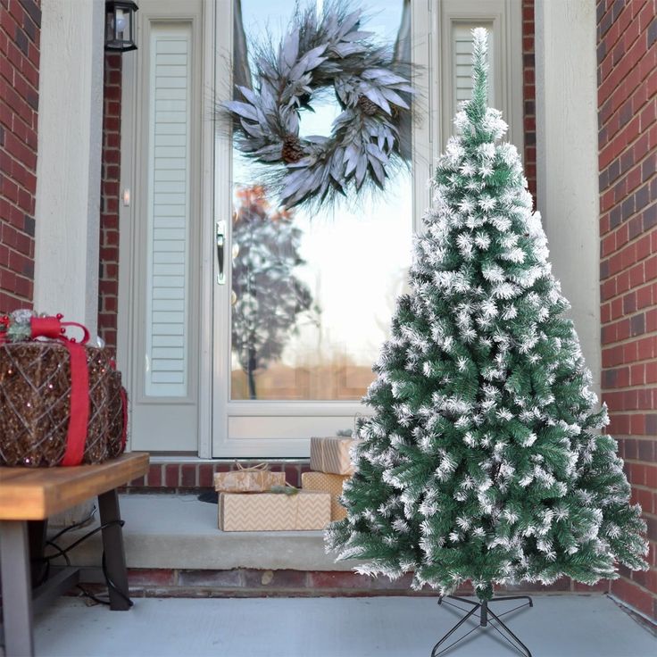 a white christmas tree sitting in front of a door