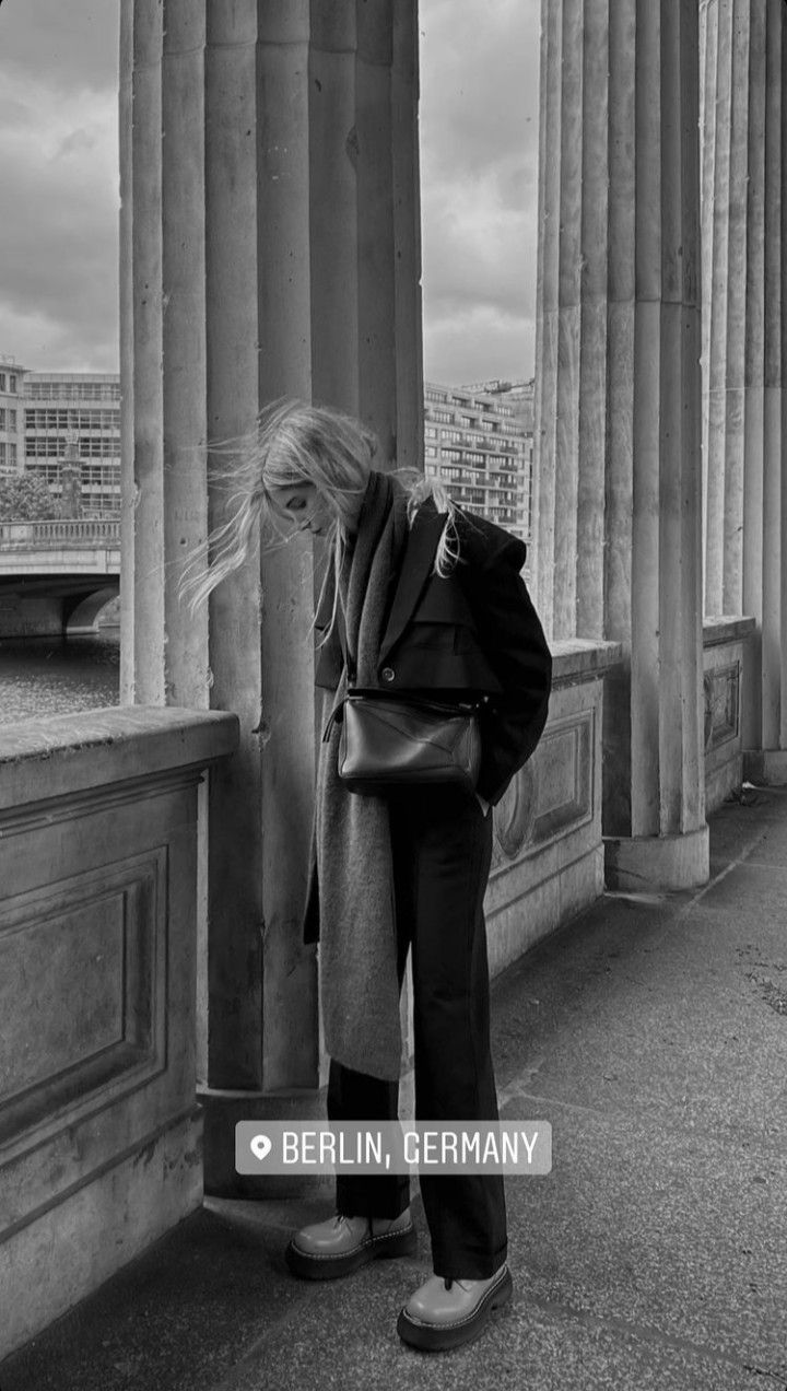 black and white photograph of a woman leaning against columns