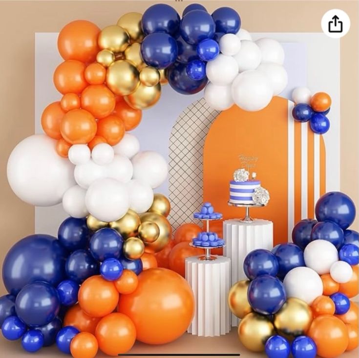 an orange, white and blue birthday party with balloons on the wall next to it