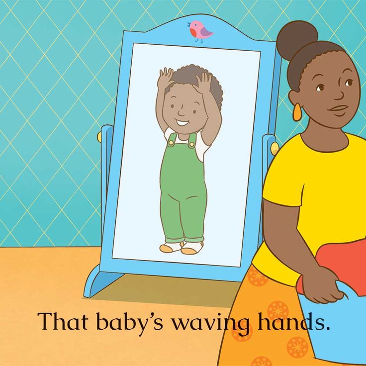 a woman standing in front of a mirror with a baby's drawing on it