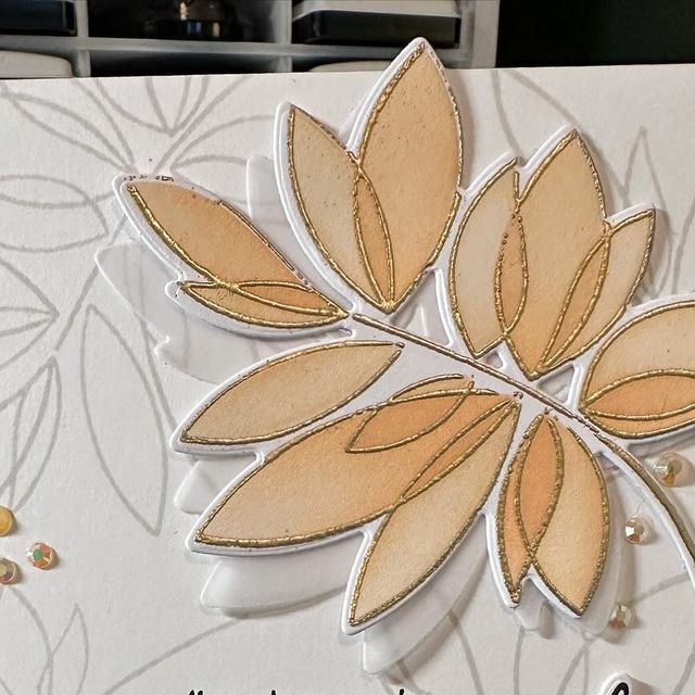 a close up of a card with a flower on the front, and some beads in the back