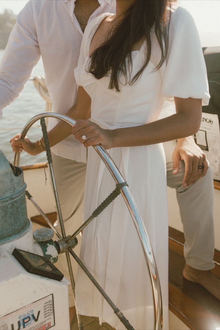 a man and woman standing on the deck of a boat