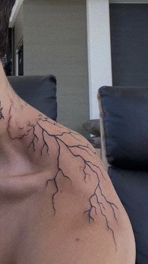 the back of a man's neck with lightning tattoo on it