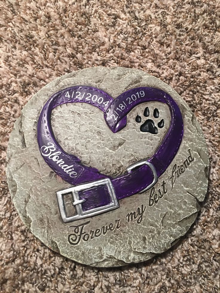 a memorial stone with a dog's paw and heart on it