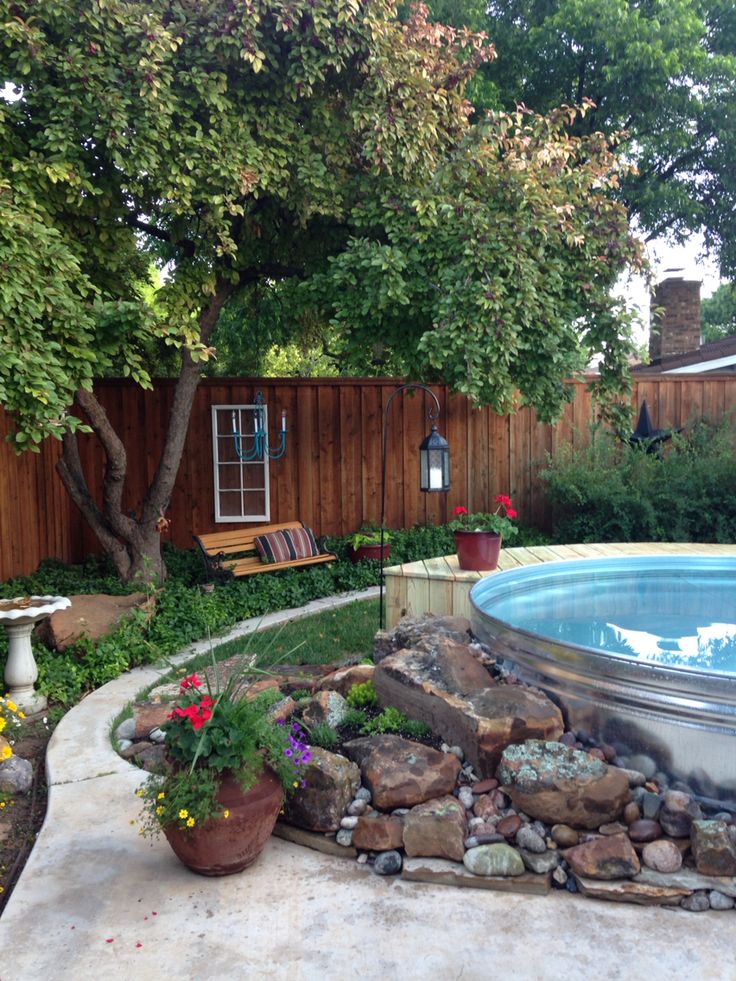 a small backyard with a pool surrounded by rocks