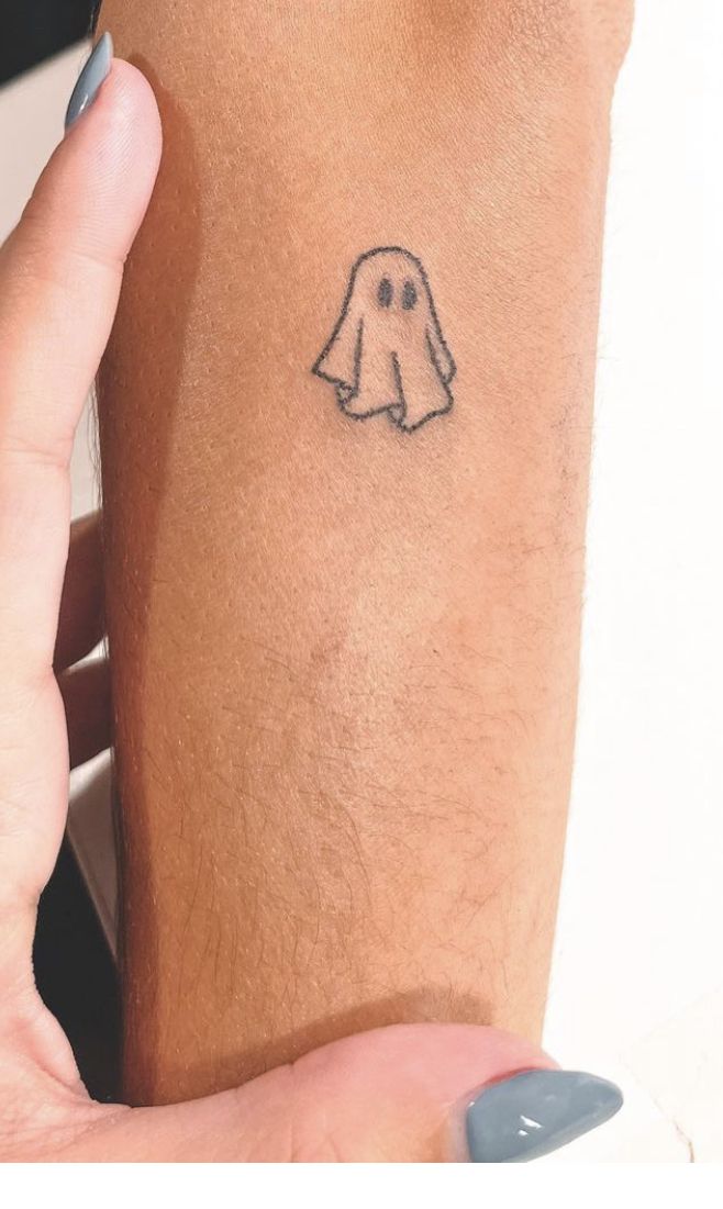 a person with a small ghost tattoo on their left arm and the word boo written in black ink