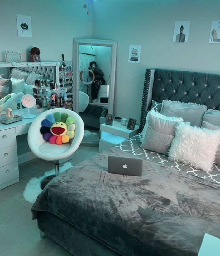 a bed room with a laptop computer on top of it next to a desk and chair