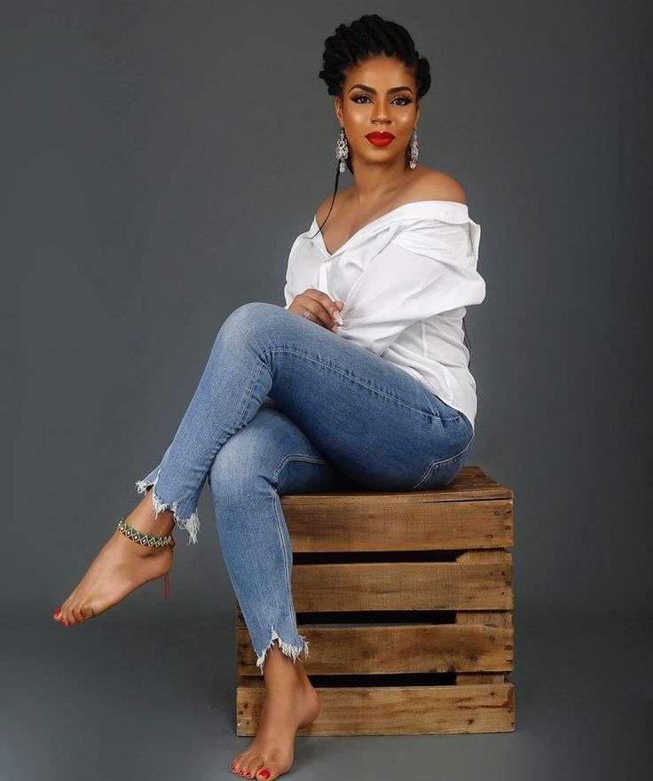 a woman sitting on top of a wooden crate