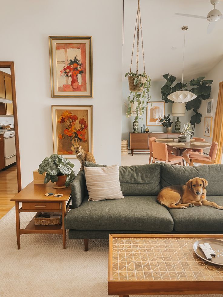 a dog laying on top of a couch in a living room next to a table