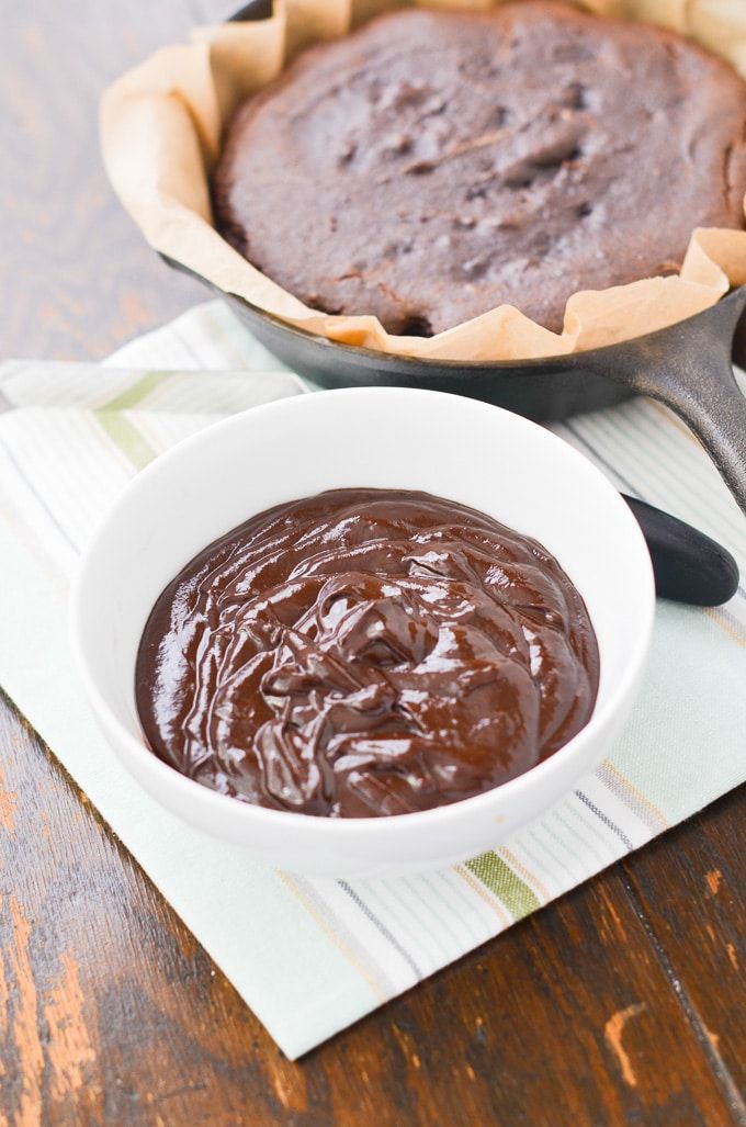 a bowl of chocolate pudding next to a pie