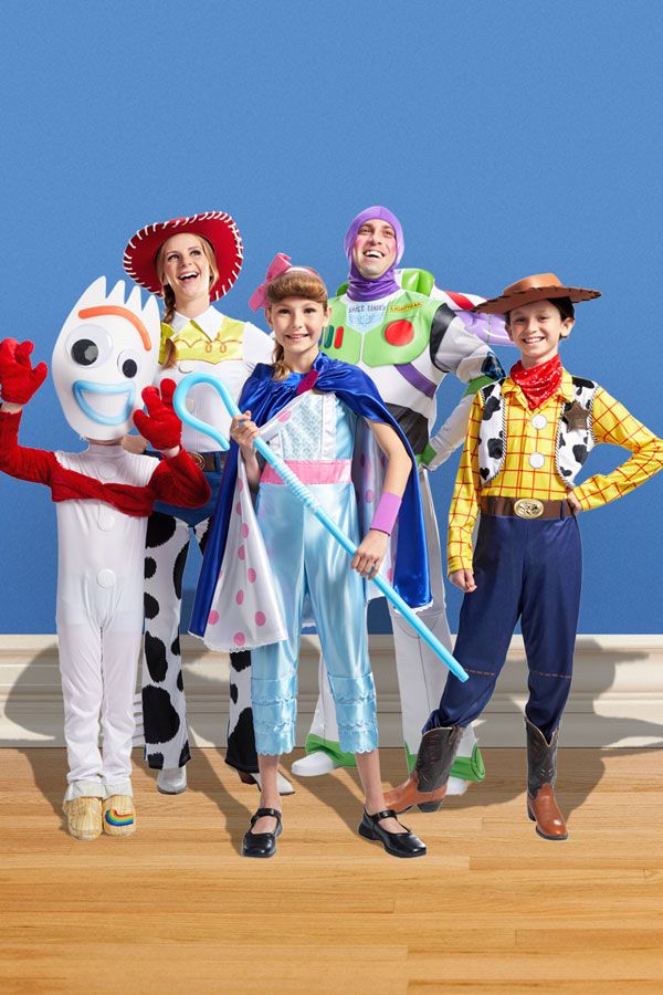 four children in costumes standing on a wooden floor with one child holding a toothbrush