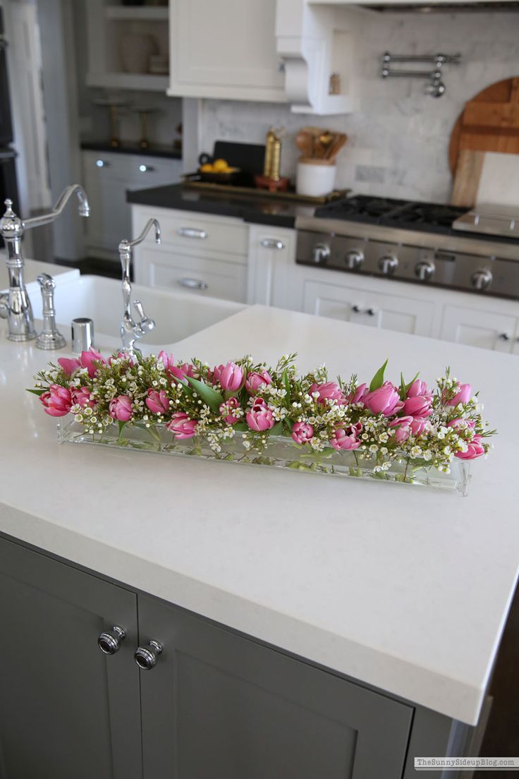 pink flowers are placed on the counter top