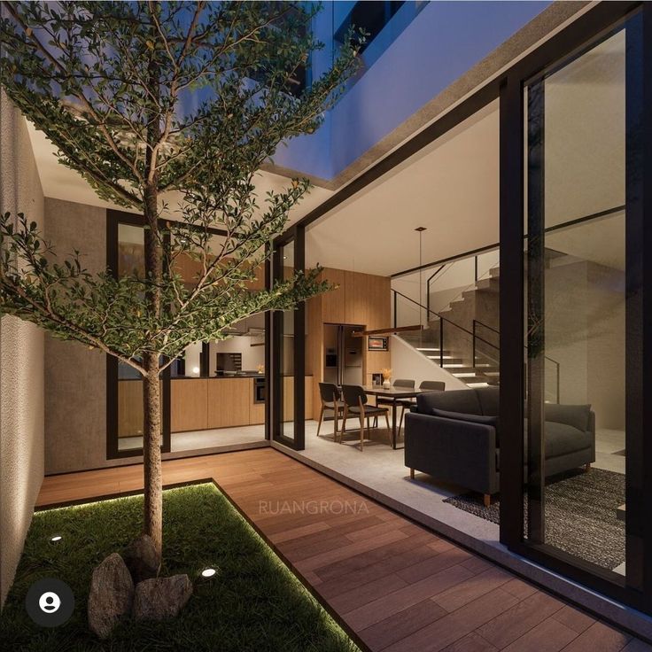 an outdoor living room and dining area are lit up at night