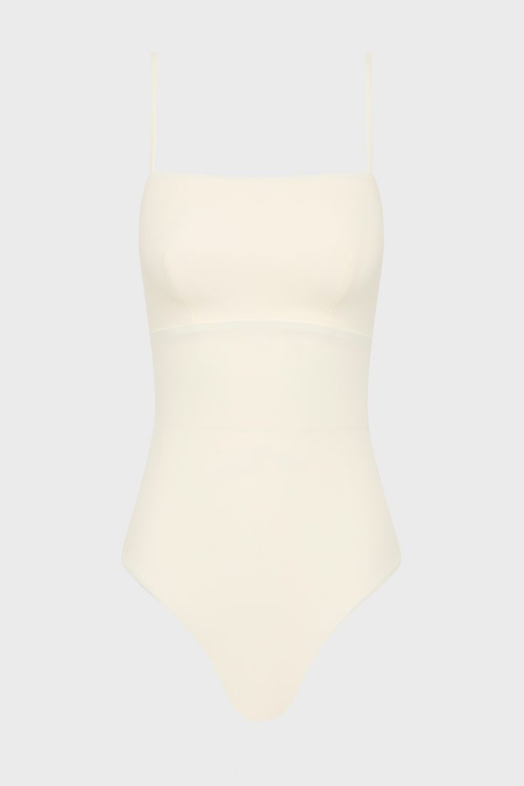 The Aerin One Piece in Pearl is an elegant, contemporary swimsuit with a flattering square neckline. With a bust panel, hidden under-bust support and removable cups, Aerin is supremely flattering to a woman's figure. Cut from our technically advanced Sculpteur® fabric with 3-D stretch, Aerin will support the bust and streamline the body. A chic swimsuit that idea for larger busts, suiting cup sizes B to DD. Luxury fabric sustainably made in Italy. Summer Swimwear With Built-in Bra And Straight Neckline, White Square Neck Swimwear For Beach, Elegant Smoothing Summer Bodysuit, Elegant Smoothing Bodysuit For Summer, Chic White Second-skin Swimwear, Elegant Summer Smoothing Bodysuit, Elegant Square Neck Stretch Swimwear, Elegant Square Neck Bodysuit, White Square Neck Swimwear For Swimming