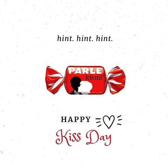 a candy bar with the words happy kiss day written in red and white on it