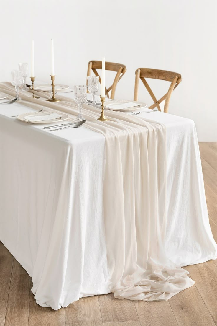 the table is set with white linens and candles