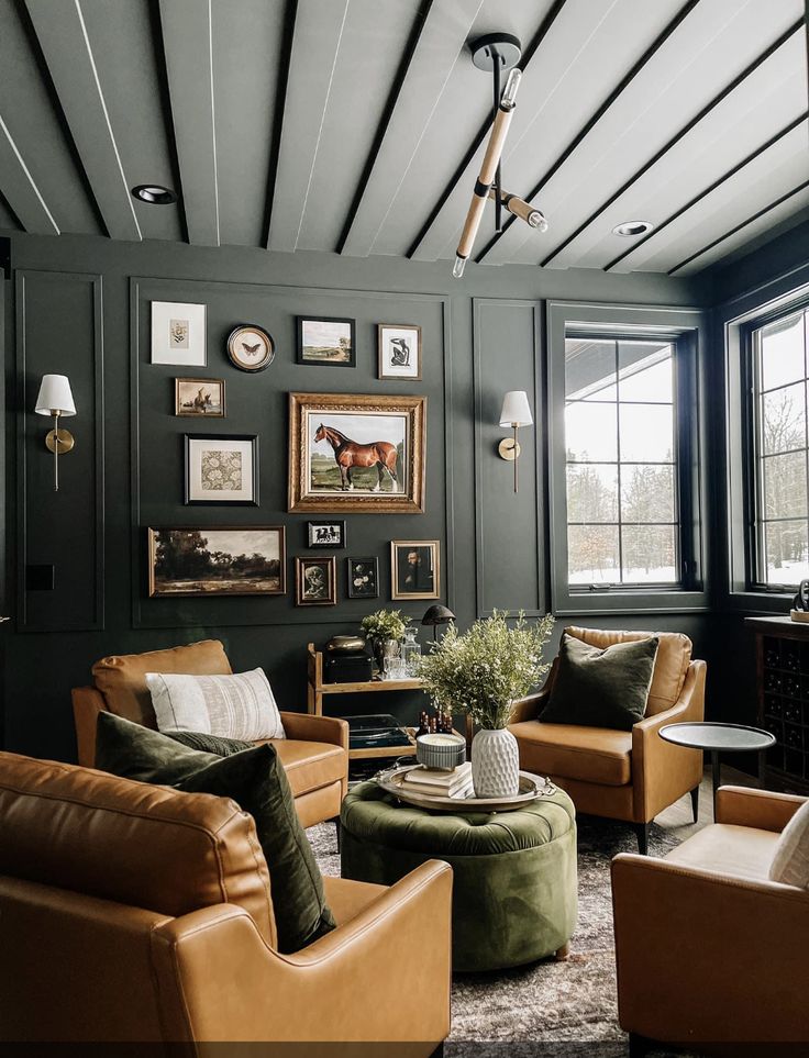 a living room with leather furniture and pictures on the wall above it's windows