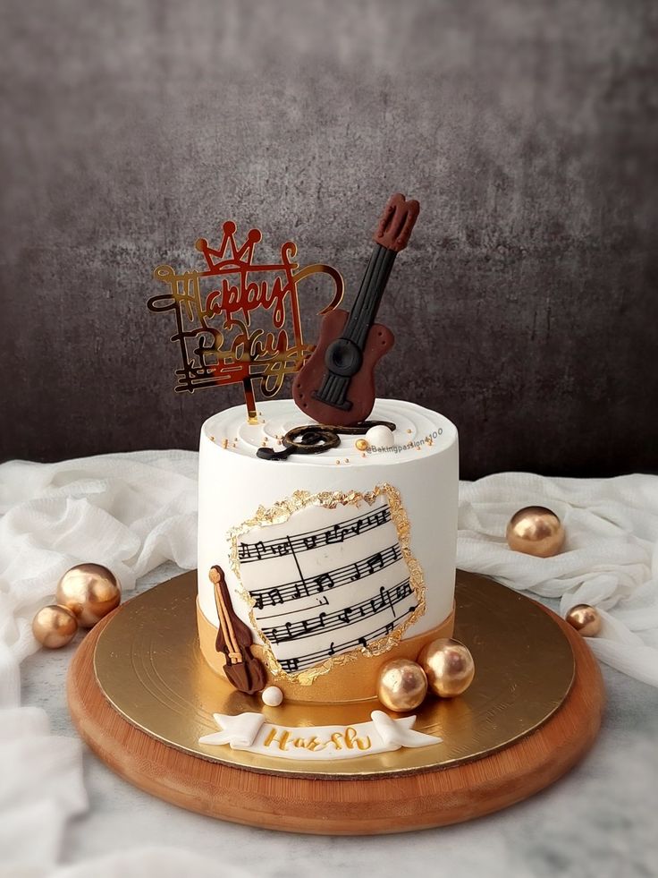 a birthday cake with musical notes and a violin on top is sitting on a gold platter