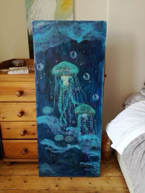 a painting of jellyfish in the ocean on a canvas next to a night stand