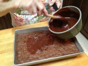 a person scooping chocolate into a pan