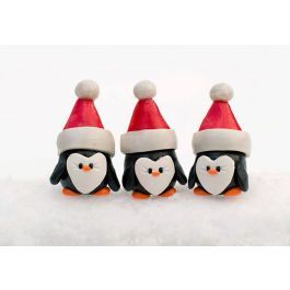 three penguins wearing santa hats on top of snow