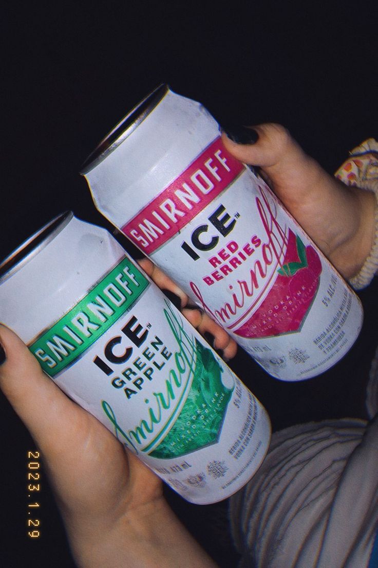 two people holding up cans of ice cream and watermelon drink in their hands