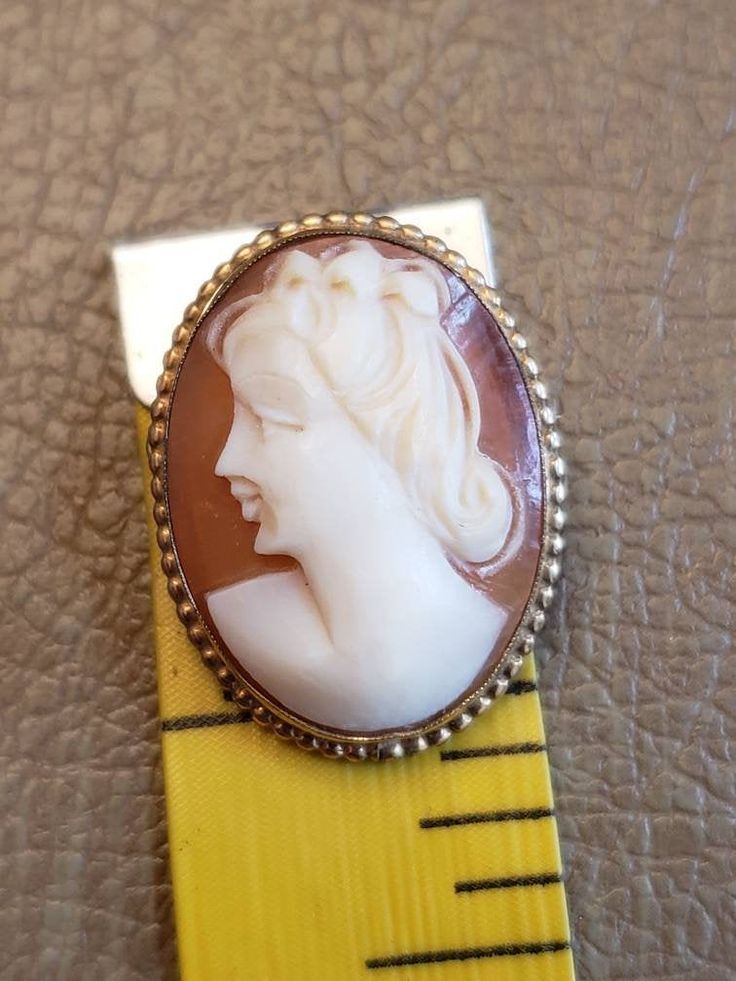 This is a vintage AMCO cameo brooch/pendant. It is oval and is stamped 1/20 14 K GF. The cameo measures just over .75 x a bit over 1 inch. Don't forget to stop in at my other Etsy shop... http://www.etsy.com/shop/xtdesigns. Follow me on Twitter at... MyYiayiaHadThat@MyYiayiaHadThat. If you have a wish list or are looking for something specific, please ask. I may have exactly what you are looking for. As always please convo me with any questions or concerns regarding this item or with any interna Vintage Cameo Brooch In Yellow Gold, Antique Oval Cameo Brooch, Vintage Yellow Gold Cameo Brooch, Vintage Oval Brooch With Cabochon, Vintage Oval Cabochon Brooch, Antique Gold Oval Brooch, Antique Gold Oval Brooches, Collectible Oval Cameo Brooch, Collectible Oval Cameo Brooches