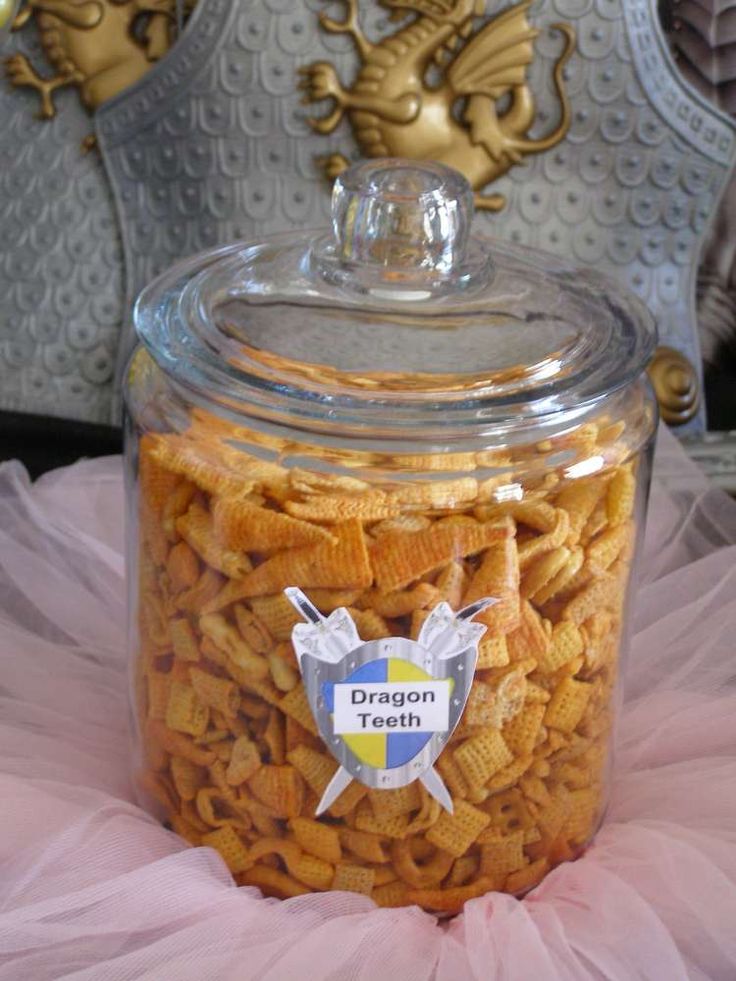 a glass jar filled with cheetos sitting on top of a pink tulle