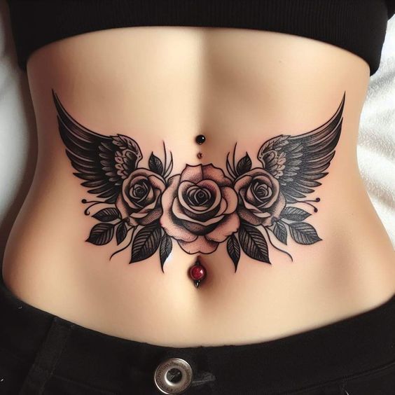 a woman's stomach with roses and wings on it